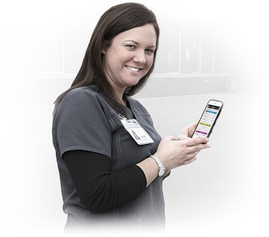 Nurse using Aladtec software on a mobile device